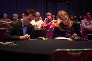 people sitting at a table taking notes