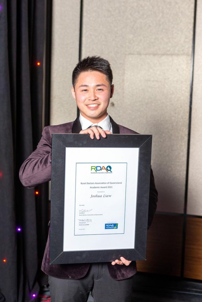 Young male holding academic award Joshua Liaw