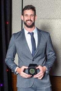 Young man holding award and smiling