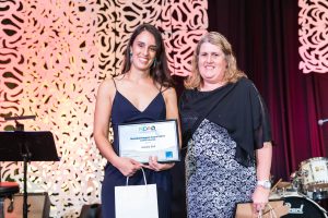 Two ladies standing together with award